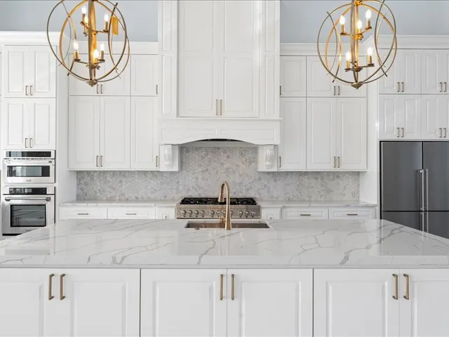 a kitchen with granite countertop a white stove top oven and cabinets