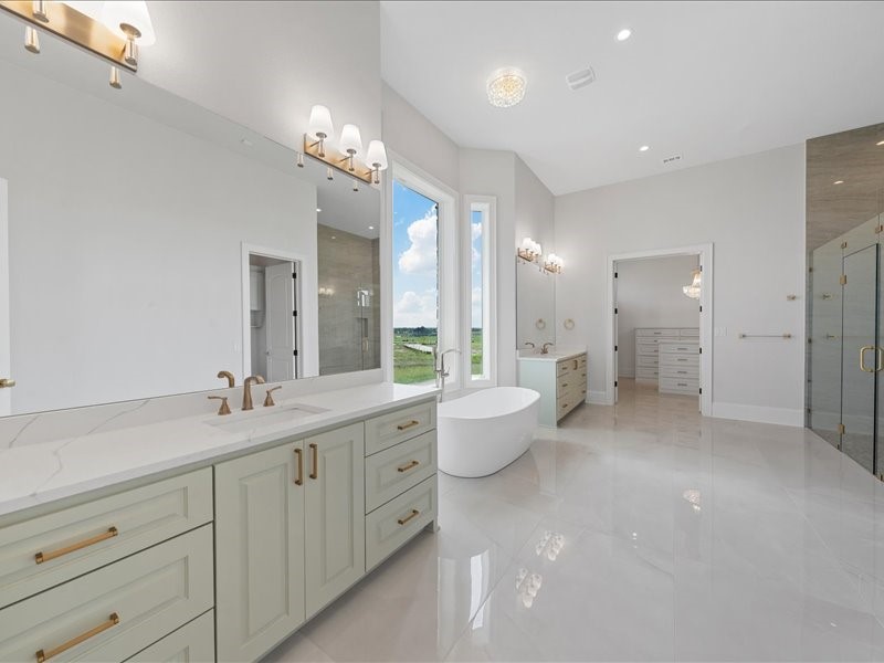 112 Yellow Rose Street Lorena, TX 76655 - Photo 21 of 42 a spacious bathroom with a double vanity sink a large mirror and a bathtub