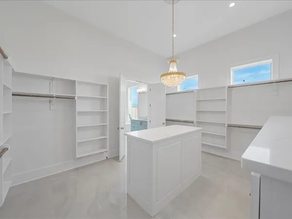 an empty room with wooden floor a ceiling fan and windows