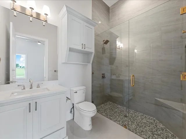a bathroom with a sink a toilet and shower