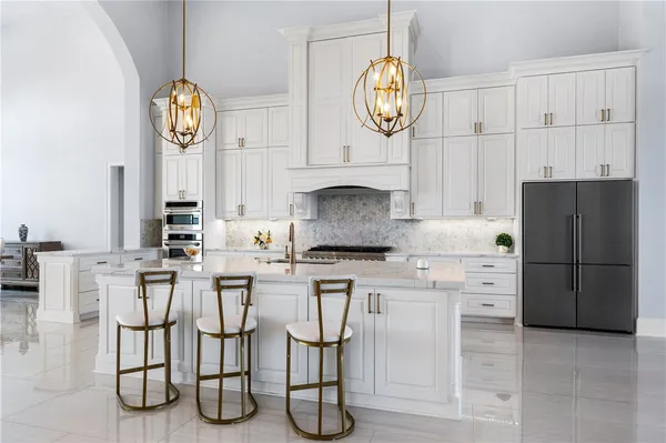 a kitchen with stainless steel appliances granite countertop a sink a stove and cabinets
