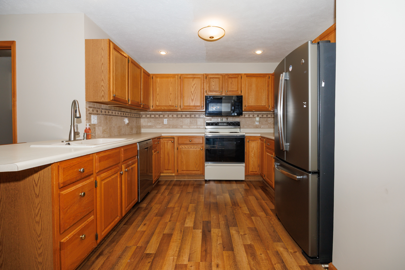 1414 B Tamarack Country Club Trail Normal, IL 61761 - Photo 14 of 48 a kitchen with stainless steel appliances granite countertop a sink stove and refrigerator