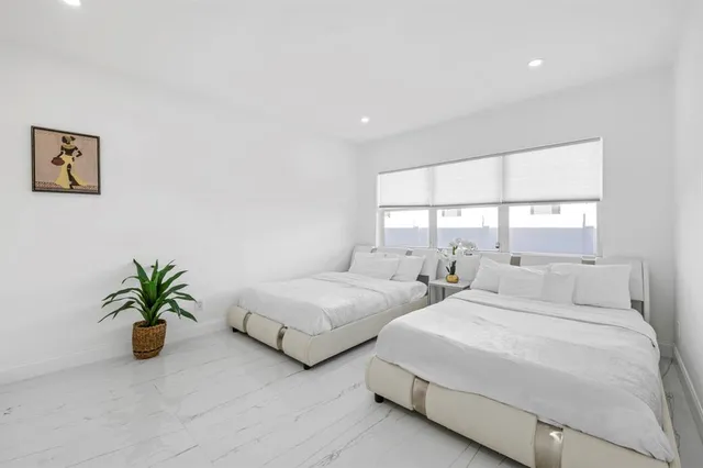 a bedroom with bed and a potted plant