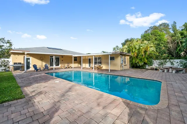a view of a house with backyard and sitting area