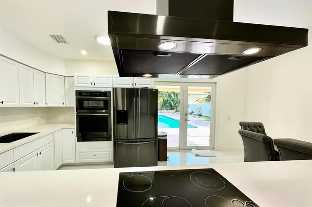 a kitchen with stainless steel appliances kitchen island granite countertop a sink and a stove