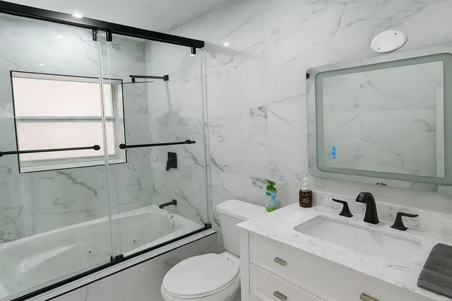 a bathroom with a sink vanity mirror and shower