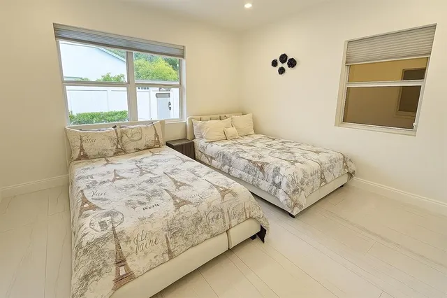 a bedroom with two beds and a large window