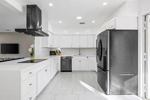 a kitchen with stainless steel appliances kitchen island granite countertop a refrigerator a sink and a stove