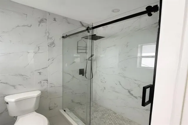 a bathroom with a shower toilet and sink