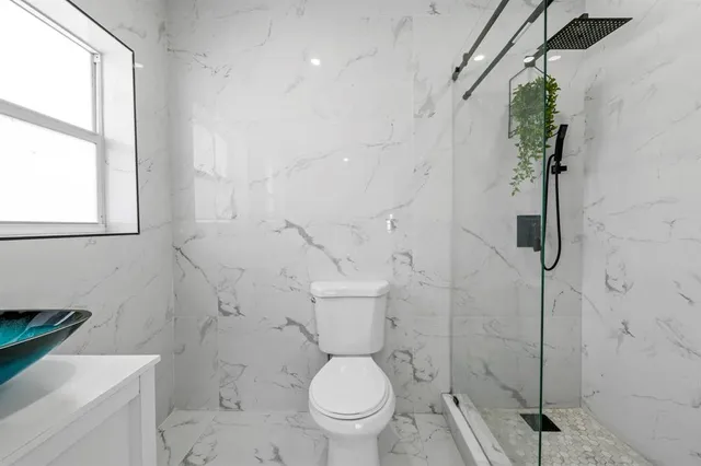 a white toilet sitting next to a bath tub shower