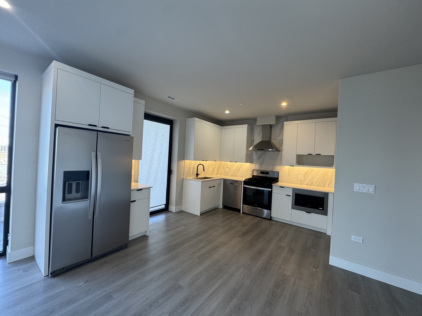 451 East Pershing Road, Unit 301 Chicago, IL 60653 - Photo 10 of 21 a kitchen with stainless steel appliances a refrigerator and a wooden floor