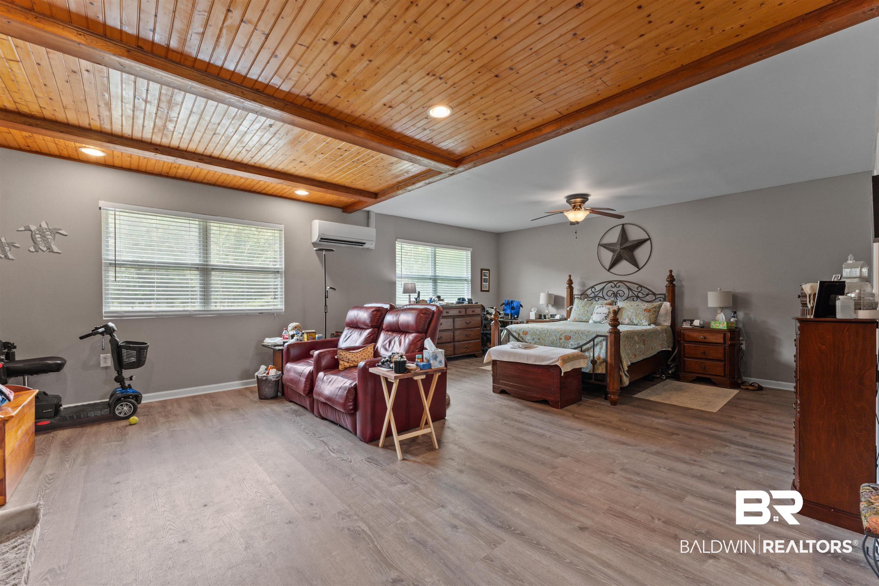 32794 Antietam Road Lillian, AL 36549 - Photo 17 of 20 Bedroom featuring a wall mounted air conditioner, wood finished floors, and a wooden ceiling with exposed beams