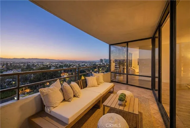 a view of a balcony with furniture and a floor to ceiling window
