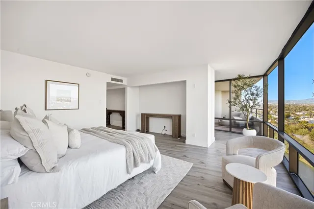 a spacious bedroom with a bed and glass windows