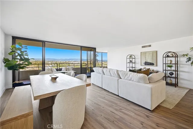 a living room with furniture kitchen view and large windows