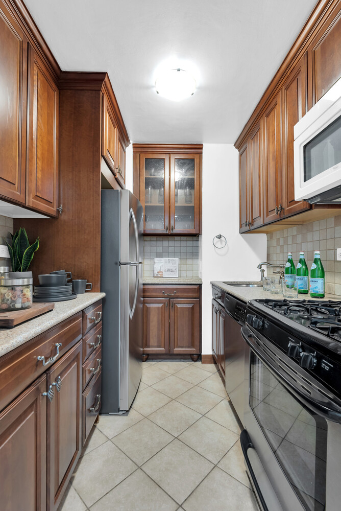 301 East 79th Street, Unit 5P Manhattan, NY 10075 - Photo 6 of 16 a kitchen with stainless steel appliances granite countertop a stove a sink dishwasher and a refrigerator