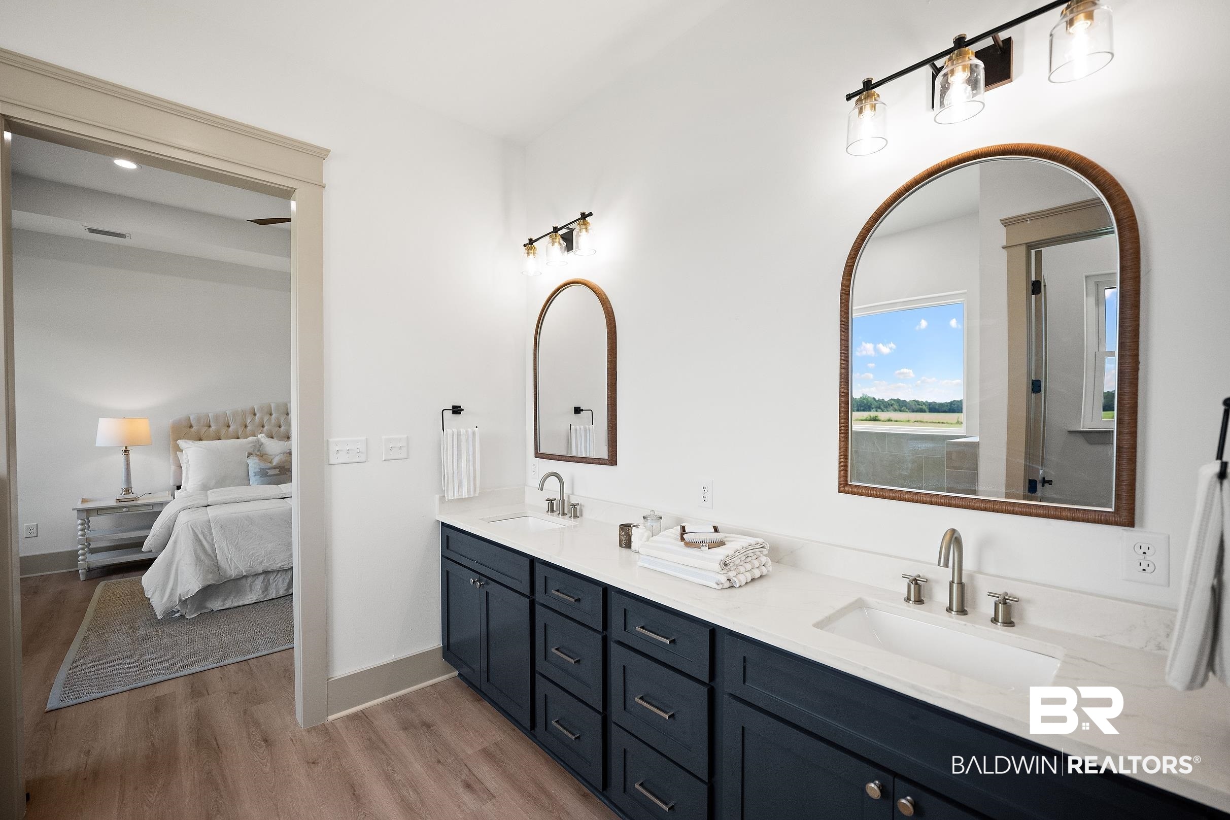 13111 Gopher Court Elberta, AL 36530 - Photo 22 of 41 Dual vanity with dark cabinetry, white countertops, and arched mirrors