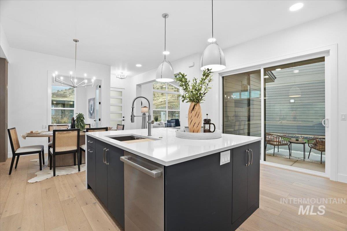 11733 North Rabbitbrush Way Boise, ID 83714 - Photo 16 of 31 Kitchen featuring dark cabinets, pendant lighting, a center island with sink, modern cabinets, and recessed lighting