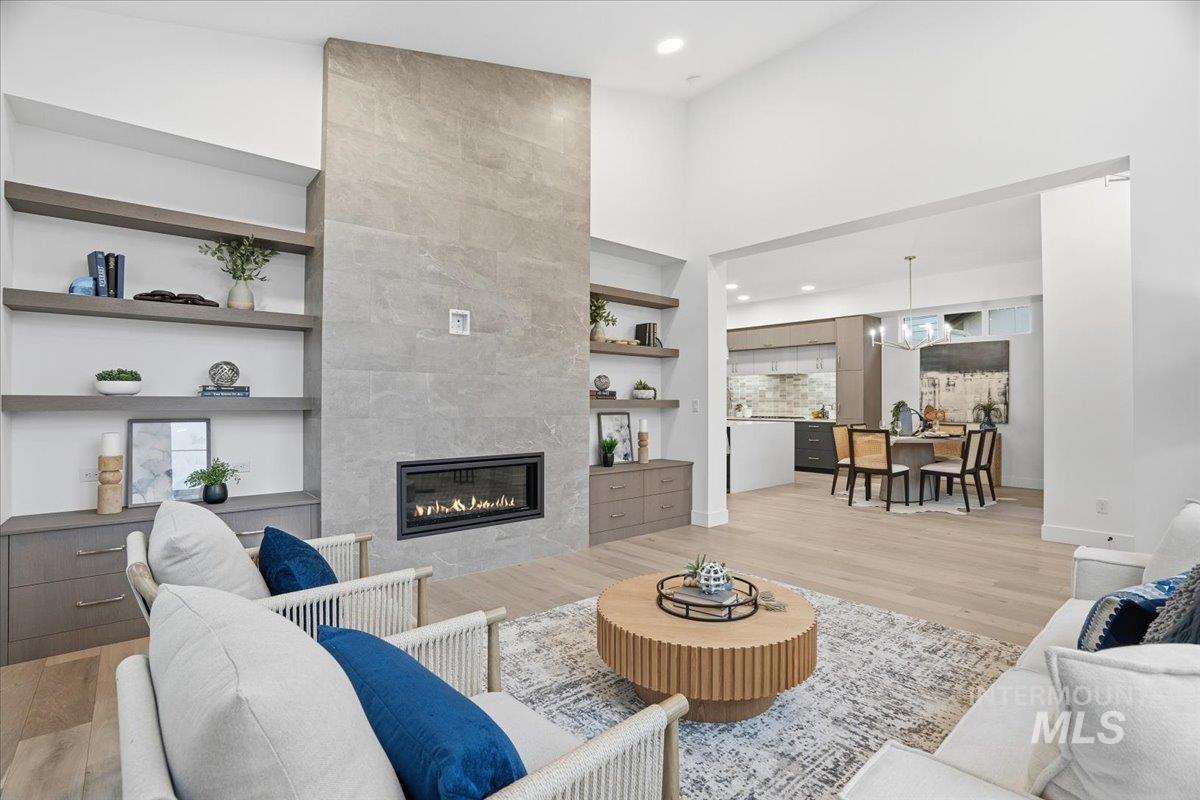 11733 North Rabbitbrush Way Boise, ID 83714 - Photo 6 of 31 Living area featuring built in features, a fireplace, light wood-type flooring, a high ceiling, and recessed lighting