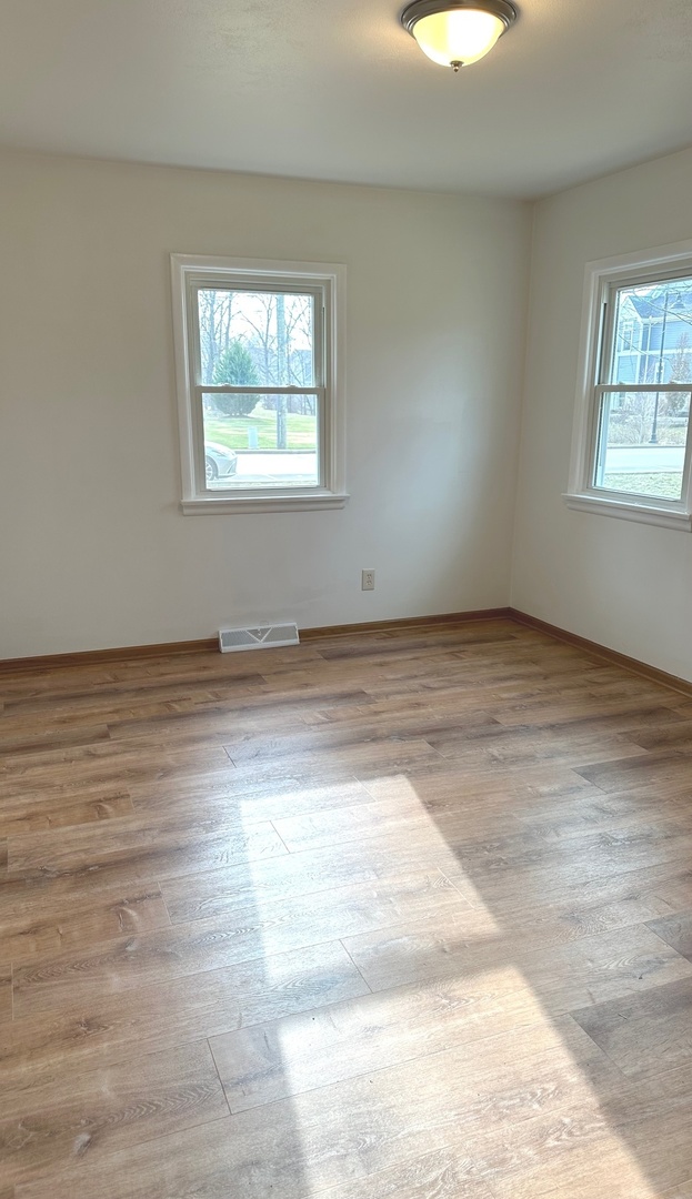 249 West Nebraska Street Frankfort, IL 60423 - Photo 8 of 18 an empty room with wooden floor and windows