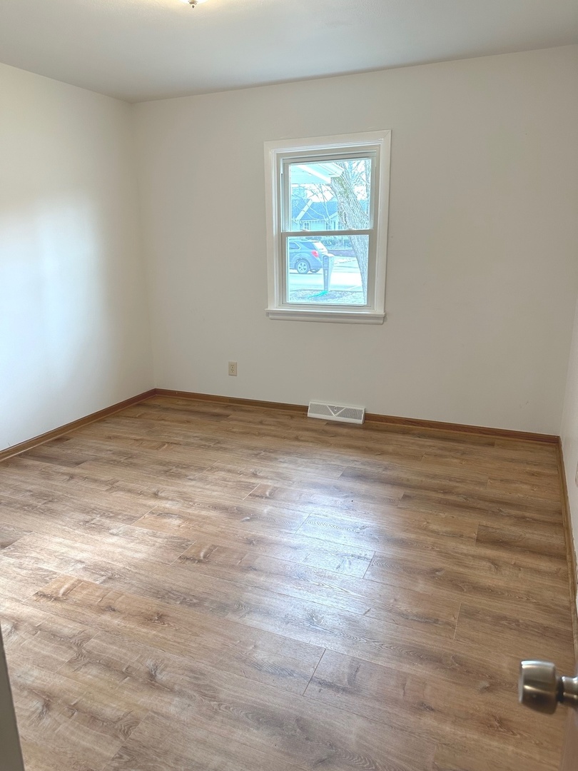 249 West Nebraska Street Frankfort, IL 60423 - Photo 10 of 18 a view of an empty room with wooden floor and a window