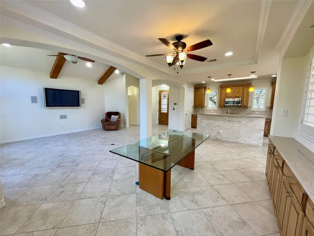 a kitchen with kitchen island granite countertop a stove a sink a counter top space and cabinets