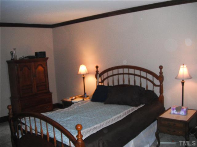 800 Ivanhoe Drive Raleigh, NC 27615 - Photo 8 of 19 a bedroom with a bed and a table in it