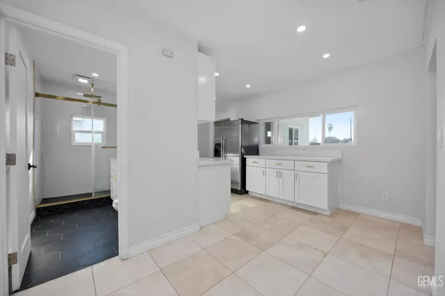 a kitchen with white cabinets and window