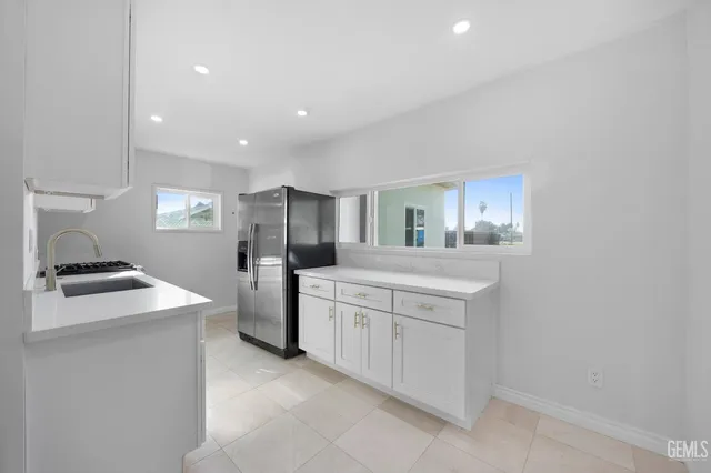 a kitchen with white cabinets and stainless steel appliances