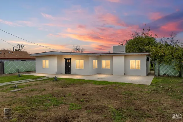 a large house with a big yard and large trees