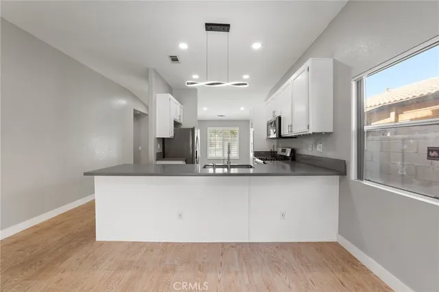 a kitchen with stainless steel appliances kitchen island granite countertop a refrigerator and a sink