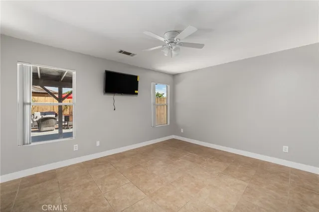 a view of an empty room with a chandelier fan