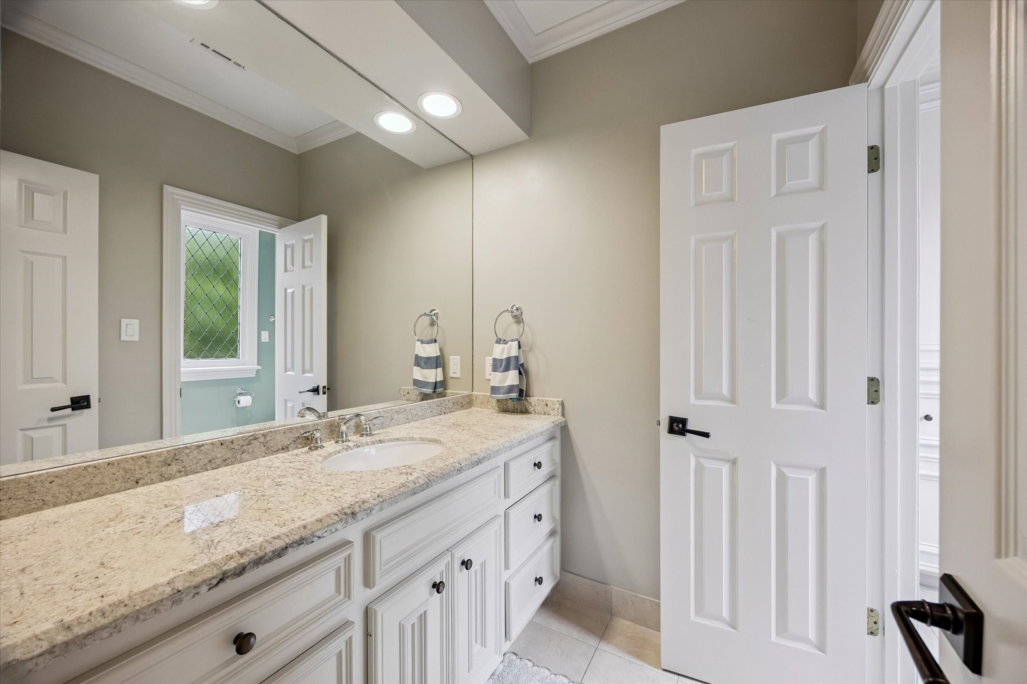 6358 Auden Street Houston, TX 77005 - Photo 31 of 50 a bathroom with a granite countertop sink and a mirror