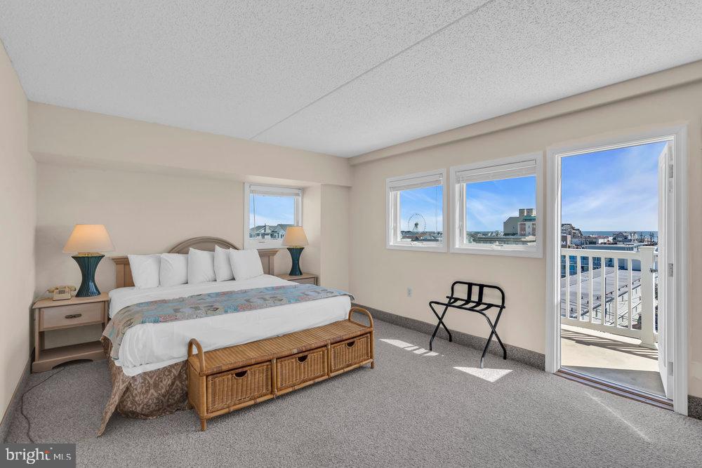 812 Ocean Avenue, Unit 420 Ocean City, NJ 08226 - Photo 11 of 20 a spacious bedroom with a bed and lamp
