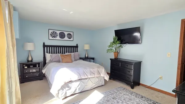 a bedroom with a bed and a flat screen tv