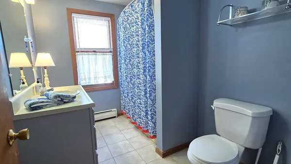 a bathroom with a sink toilet and window