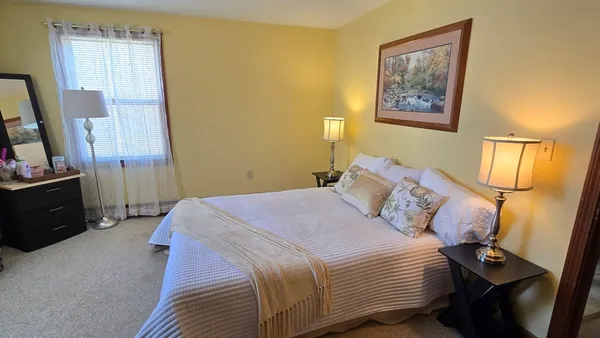 a bedroom with a bed and a flat tv screen on a dresser