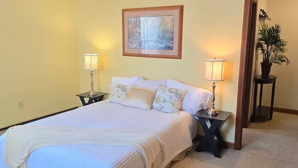 a bedroom with a bed and a painting on the wall