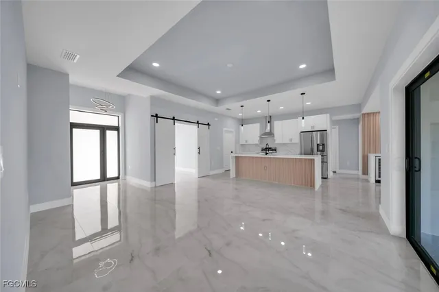 a view of a kitchen with refrigerator and windows