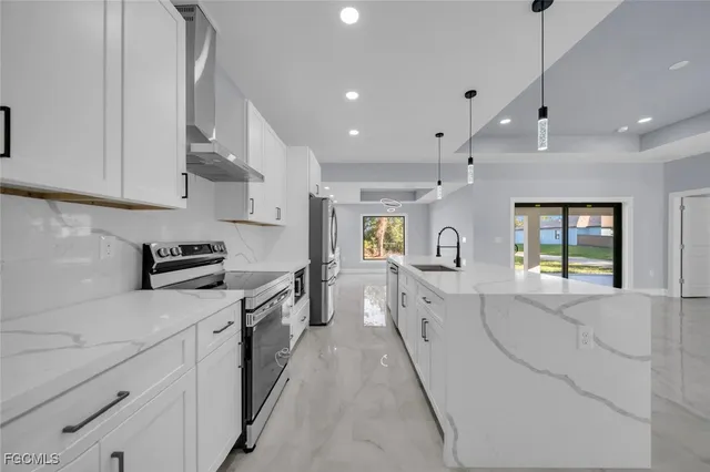 a large kitchen with stainless steel appliances lots of counter space sink and a window