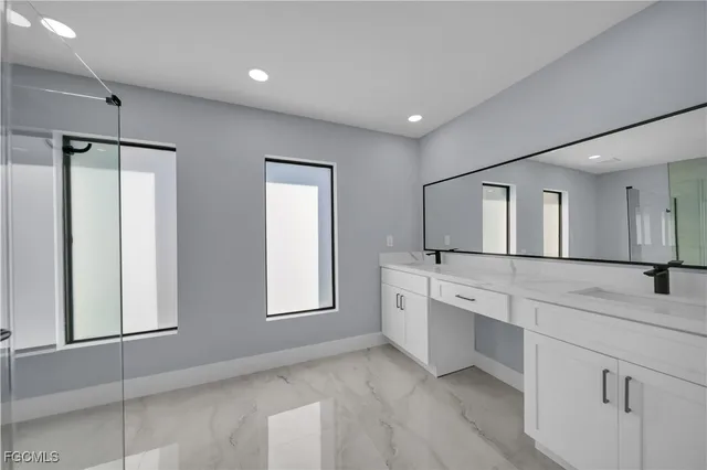 a spacious bathroom with a granite countertop sink mirror and bathtub