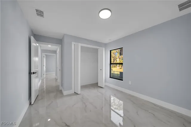 an empty room with windows and cabinet