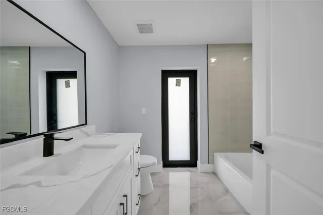 a bathroom with a tub sink and mirror