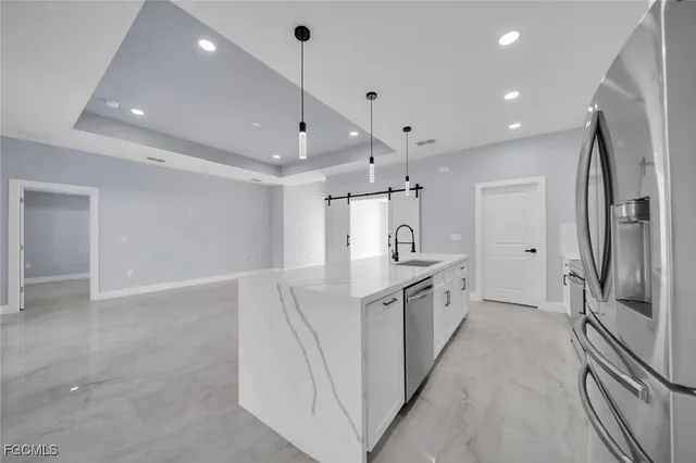 a large kitchen with a sink and stainless steel appliances