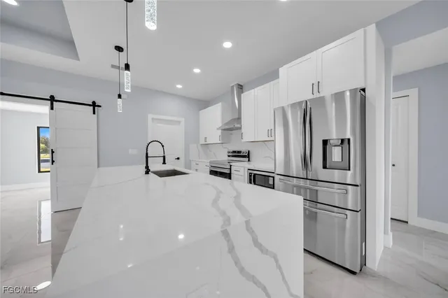 a kitchen with stainless steel appliances a refrigerator sink and microwave