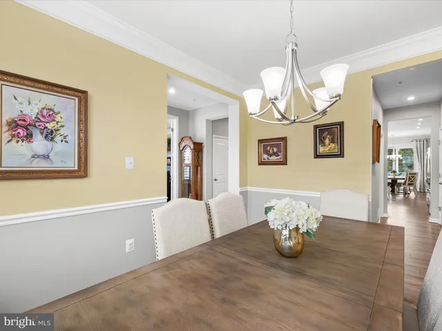 a view of a dining room with furniture a chandelier and wooden floor