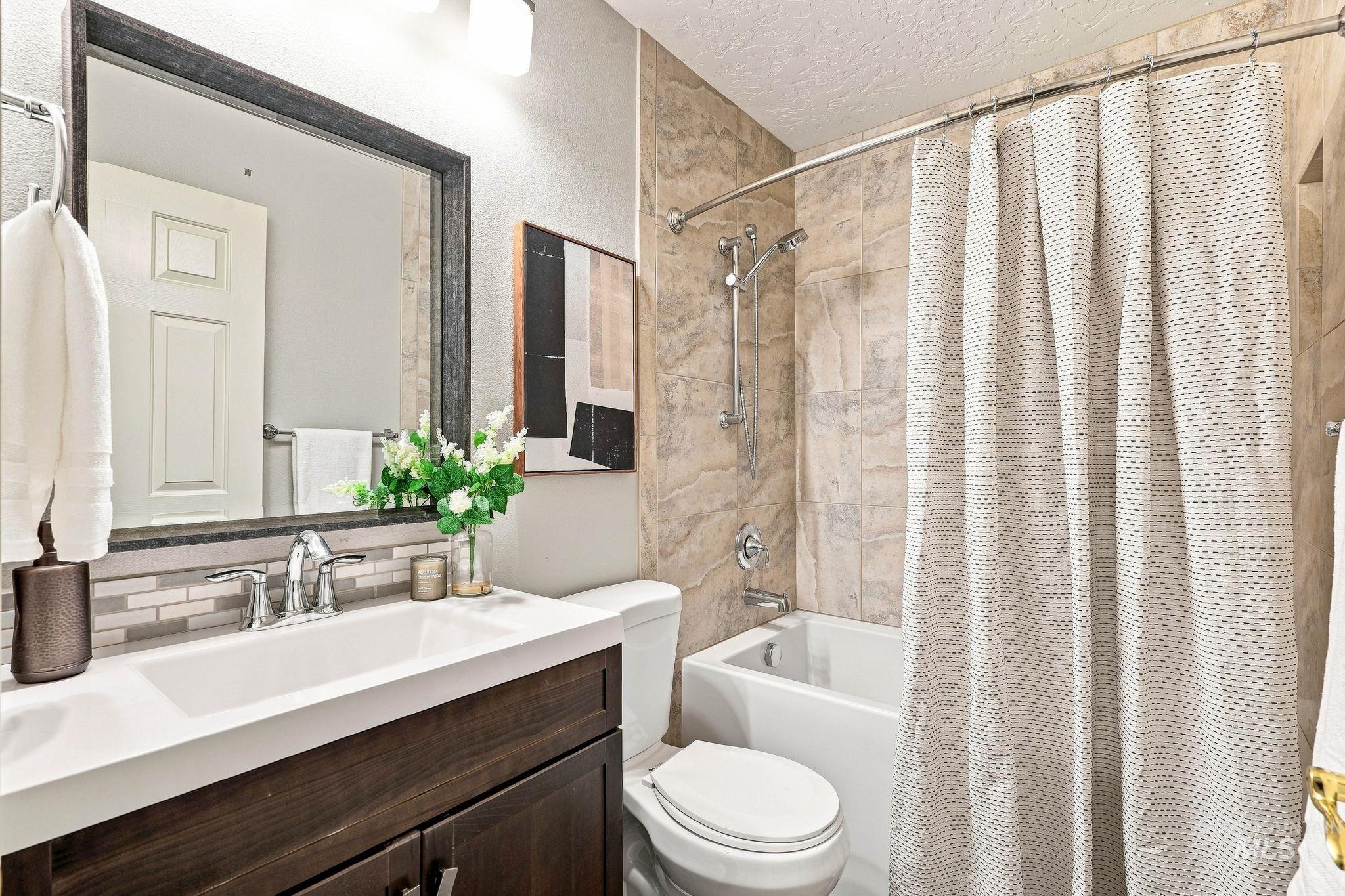 2442 West Hill Road Boise, ID 83702 - Photo 26 of 48 Sleek vanity with chrome fixtures and a rectangular undermount sink, complemented by a mosaic tile backsplash