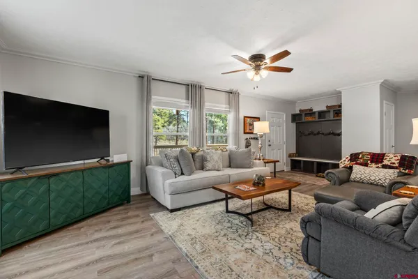 a living room with furniture ceiling fan and a window