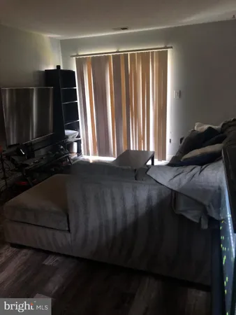 a bedroom with a bed tv and a window