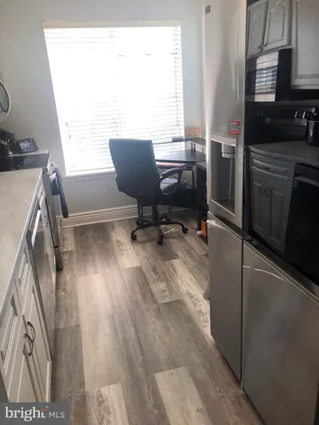 a view of a workspace with furniture and a window